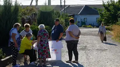 Local residents gather at a mobile polling station during early voting in Russia's