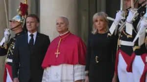 Pope Leo XIV, center, is welcomed by French President Emmanuel Macron, left, and his wife