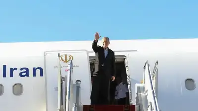 Pezeshkian waves to media and officials as he boards his plane while leaving Mehrabad airport