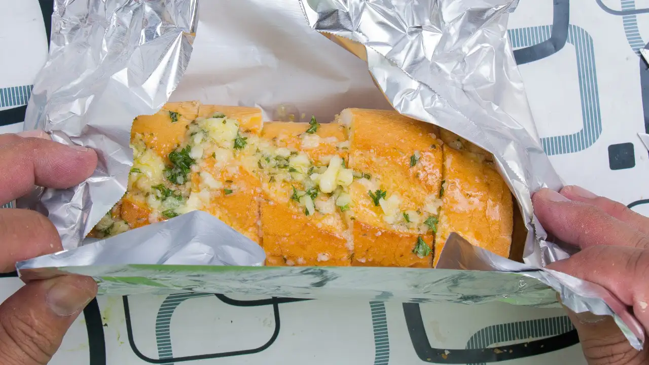 Aluminium foil can help slow moisture loss and protect bread from drying out, but it does not