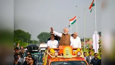 Prime Minister Narendra Modi greets the supporters during a roadshow as Gujarat chief minister