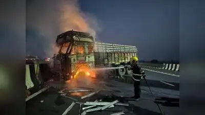 A firefighter douses a truck after a tyre burst triggered a blaze on Samruddhi Expressway