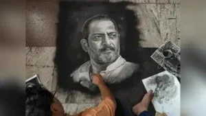 Rangoli artist Shreehari Pavale works on a rangoli portrait paying tribute to veteran actor