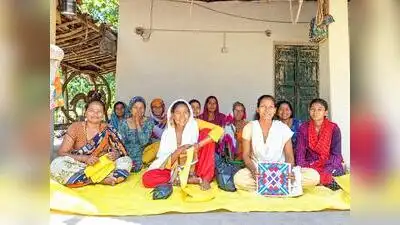 A group of traditionally dressed tharu women welcoming tourists at a home stay
