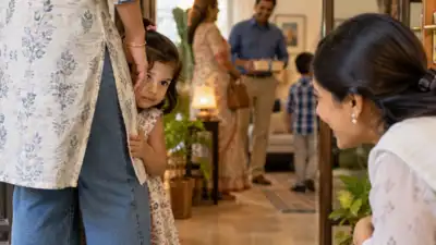 When a toddler hides behind your legs but continues peeking at guests, the behaviour may