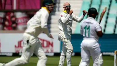 Australia's Nathan Lyon, center, celebrates with his teammates after dismissing South Africa's