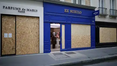 View of shops with display windows protected by wooden panels days ahead of a second round