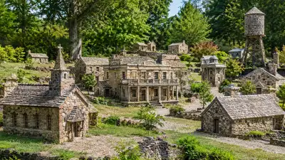A miniature stone village featuring small buildings, including a church, hotel and water tower