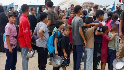 Palestinian children wait to receive food from a soup kitchen funded by the World Food