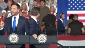 Just few minutes into Vance’s address, a man standing directly behind the vice-president stood