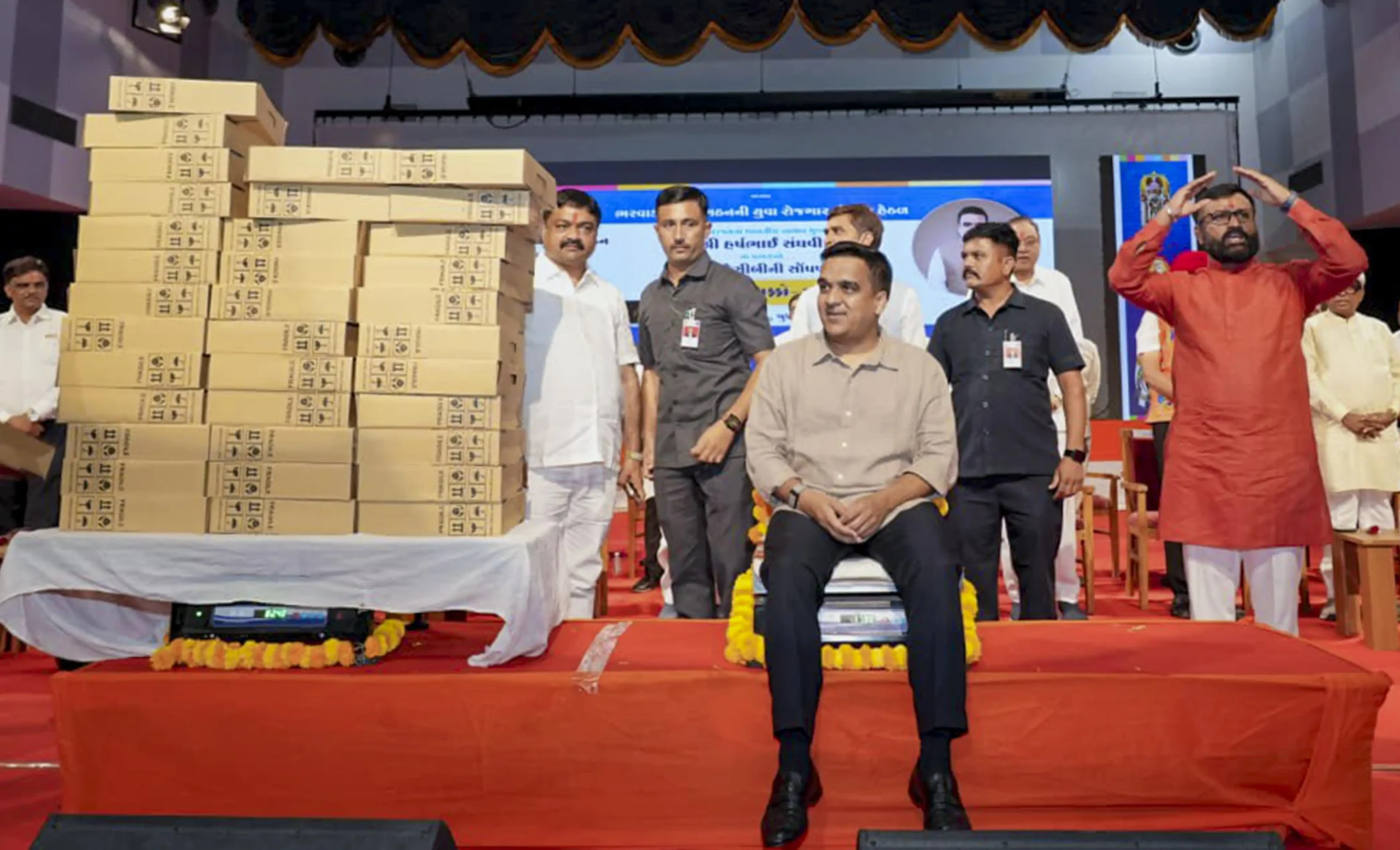 14, 2026 DyCM Harsh Sanghavi hands over a ceremonial key of an earthmover to a beneficiary