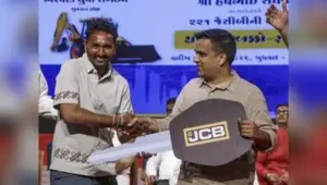 14, 2026 DyCM Harsh Sanghavi hands over a ceremonial key of an earthmover to a beneficiary