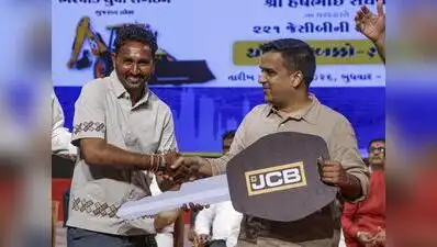 14, 2026 DyCM Harsh Sanghavi hands over a ceremonial key of an earthmover to a beneficiary
