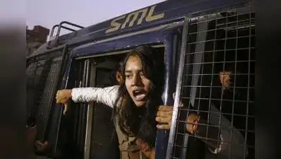10, 2026 A man climb on a police vehicle is detained by police during a protest demanding